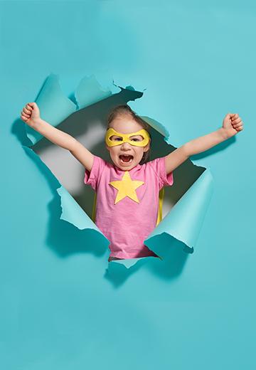 strong child busting through blue paper wall