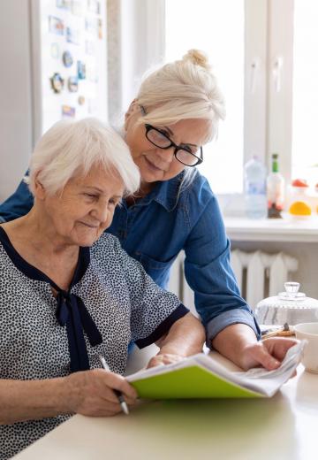 Elderly woman and daughter looking at paperwork
