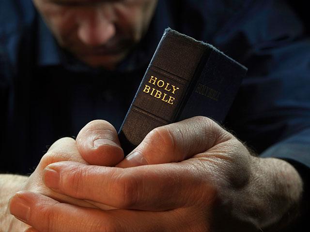 man praying with Bible
