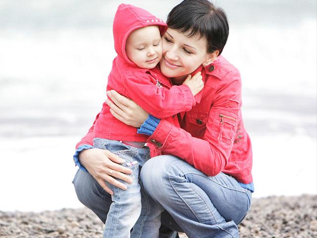 mother hugging toddler on the shore