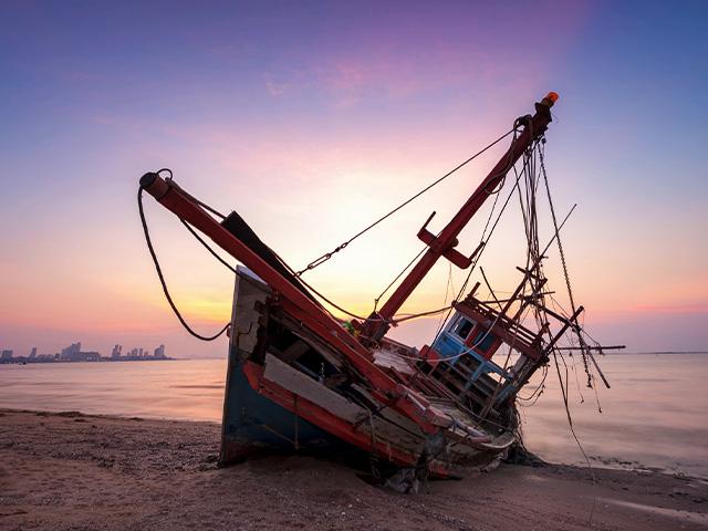 a sailboat shipwrecked on the beach