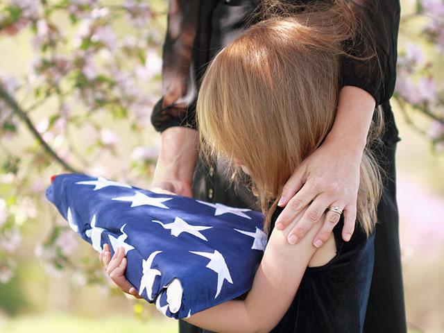 Daughter holding a folded American flag