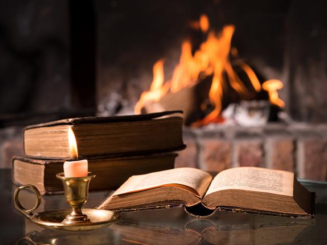 open Bible near a fireplace