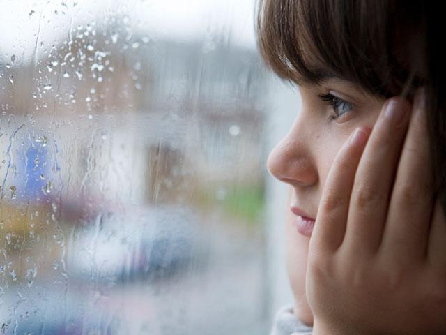 Girl looking out at the rain