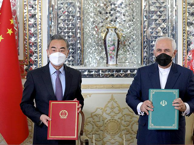 Iranian Foreign Minister Mohammad Javad Zarif, right, and his Chinese counterpart Wang Yi, pose for photos after the ceremony of signing documents, in Tehran, Iran, Saturday, March 27, 2021. (AP Photo/Ebrahim Noroozi)