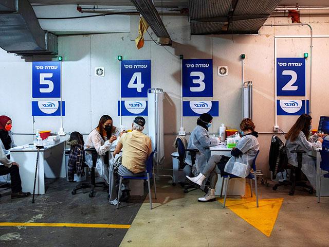 Israelis receive a Pfizer-BioNTech COVID-19 vaccine from medical professionals at a vaccination center set up on a mall parking lot in Givataim, Israel.  (AP Photo/Oded Balilty)