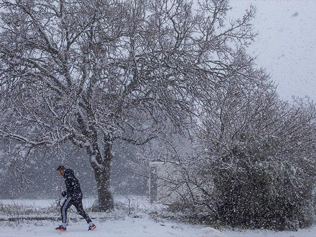 A man walks in the snow near the Quneitra border crossing between Syria and the Israeli-controlled Golan Heights Wednesday, Feb. 17, 2021. (AP Photo/Ariel Schalit)