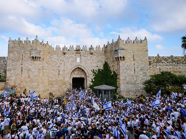 Israelis wave national flags during a march marking Jerusalem Day in front of the Damascus Gate of Jerusalem&#039;s Old City, Thursday, May 18, 2023. (AP Photo/Ohad Zwigenberg)