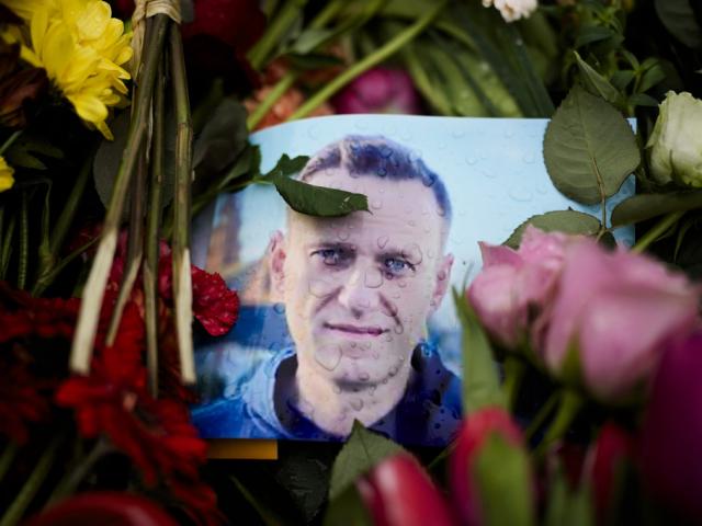 A portrait of Russian opposition leader Alexei Navalny between flowers at the Russian embassy in Berlin, Feb. 21, 2024  (AP Photo/Markus Schreiber)