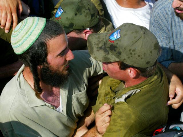 An Israeli army officer scuffles with a Jewish settler in the Jewish settlement of Neve Dekalim, in the Gush Katif bloc of settlements Monday Aug. 15, 2005. (AP Photo/David Guttenfelder)