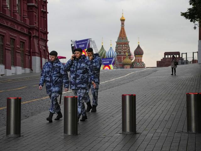 Policemen walk at Red Square with the St. Basil&#039;s Cathedral and Lenin Mausoleum in the background ahead of a planned concert in Moscow, Russia, Thursday, Sept. 29, 2022. (AP Photo/Alexander Zemlianichenko)