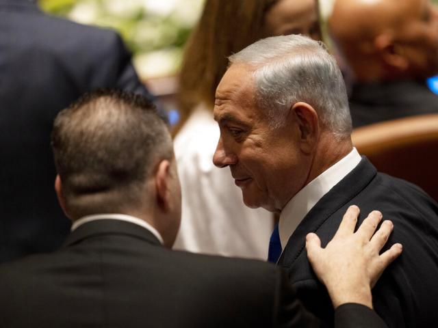 Israel&#039;s incoming Prime Minister Benjamin Netanyahu speaks with a colleague at the swearing-in ceremony for Israel&#039;s parliament, at the Knesset, in Jerusalem, Tuesday, Nov. 15, 2022. (AP Photo/ Maya Alleruzzo, Pool)
