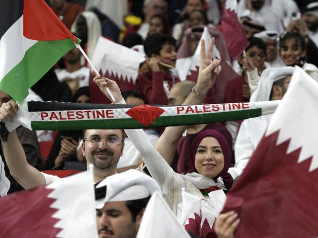 Fans wave the Palestinian flag and cheer prior the World Cup, group A soccer match between Qatar and Ecuador at the Al Bayt Stadium in Al Khor, Sunday, Nov. 20, 2022. (AP Photo/Ariel Schalit)