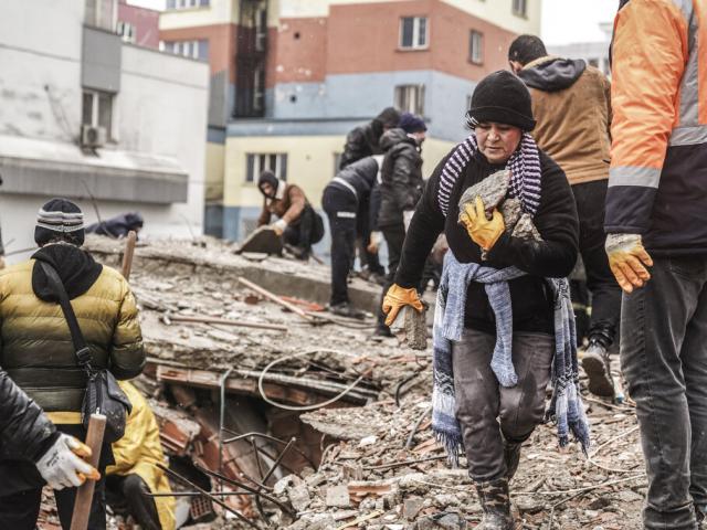 People and emergency teams search for people in the rubble in a destroyed building in Gaziantep, Turkey, Monday, Feb. 6, 2023. (AP Photo/Mustafa Karali)