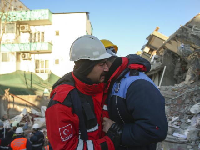 Rescuers weep by a collapsed building in Adiyaman, southern Turkey, Thursday, Feb. 9, 2023. ( AP Photo/Emrah Gurel)