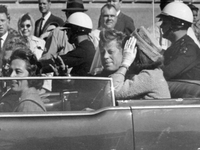  President John F. Kennedy waves from his car in a motorcade approximately one minute before he was shot, Nov. 22, 1963, in Dallas. (AP Photo/Jim Altgens, File)