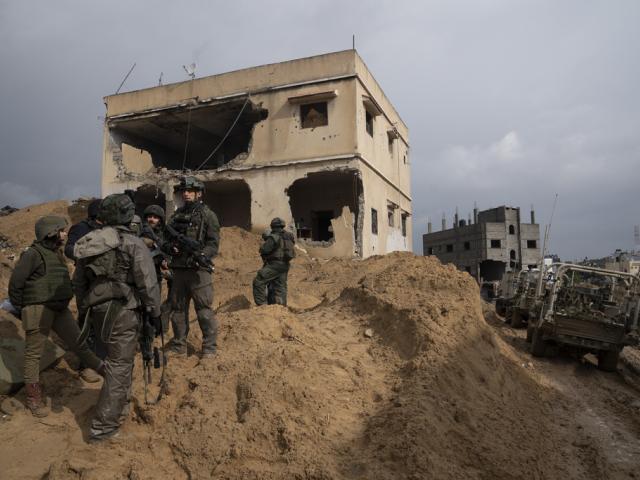 Israeli soldiers stand outside a building during the ground offensive on the Gaza Strip in Khan Younis, Saturday, Jan. 27, 2024. (AP Photo/Sam McNeil)