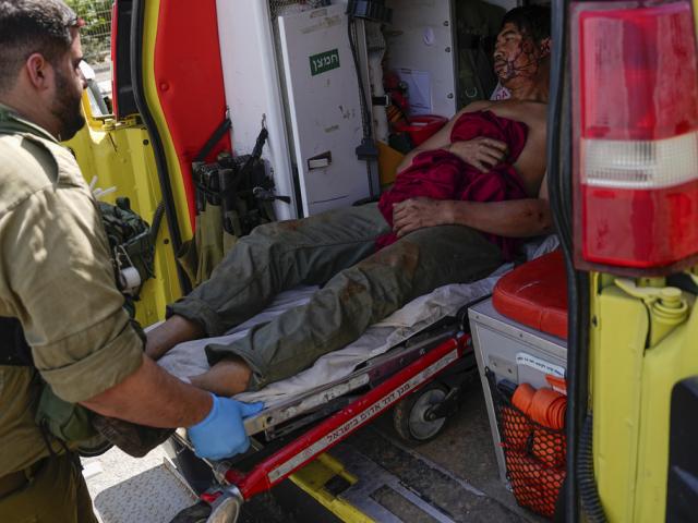 Israeli security forces in Kiryat Shoma, northern Israel, evacuate a wounded Thai man after he was hit by an anti-tank missile fired from Lebanon, in a nearby village on Monday, March 4, 2024. (AP Photo/Ariel Schalit)