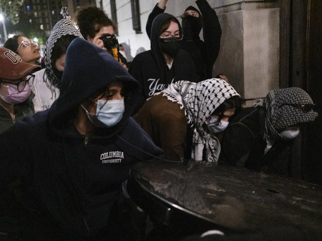 Students with the Gaza Solidarity Encampment block the entrance of Hamilton Hall at Columbia University after taking it over on Tuesday, April 30, 2024 in New York.  (Marco Postigo Storel via AP)