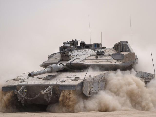 An Israeli soldier moves on the top of a tank near the Israeli-Gaza border, as seen from southern Israel, Tuesday, May 28, 2024. (AP Photo/Leo Correa)