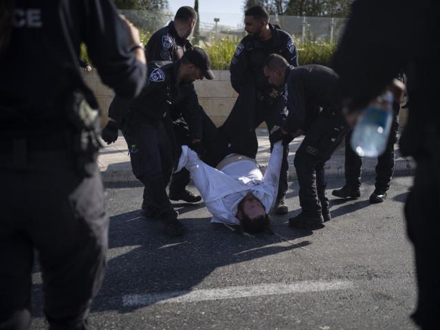  Israeli police officers remove an ultra-Orthodox Jewish man from the street during a protest against army recruitment in Jerusalem on June 2, 2024.  (AP Photo/Leo Correa, File)