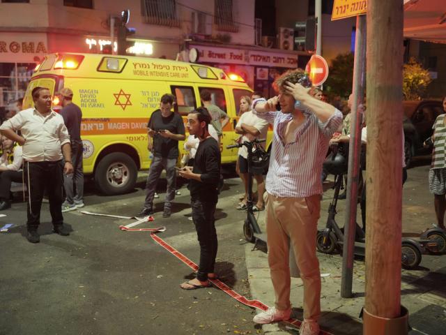 People gather at the scene of an deadly explosion in Tel Aviv, Israel, early Friday, July 19, 2024. (AP Photo/Erik Marmor)