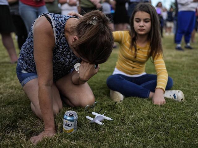 Brandy Rickaba and her daughter Emilie pray during a candlelight vigil for the slain students and teachers at Apalachee High School, Wednesday, Sept. 4, 2024, in Winder, Ga. (AP Photo/Mike Stewart)