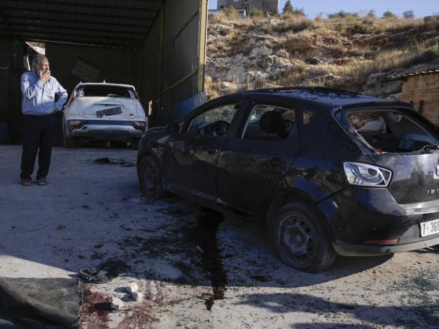 Palestinians look at a damaged car following an Israeli airstrike in Tubas, West Bank, Thursday, Sept. 5, 2024. (AP Photo/Majdi Mohammed)