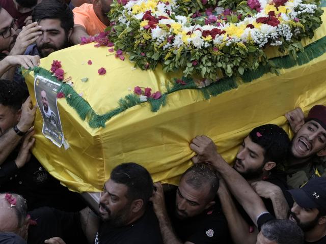 Hezbollah fighters carry one of the coffins of four fallen comrades who were killed Tuesday after their handheld pagers exploded, in the southern suburb of Beirut, Lebanon, Wednesday, Sept. 18, 2024. (AP Photo/Bilal Hussein)