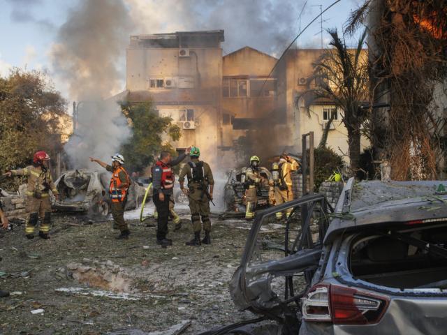 Israeli security forces work at the site hit by a rocket fired from Lebanon, in Kiryat Bialik, northern Israel, on Sunday, Sept. 22, 2024. (AP Photo/Gil Nechushtan)