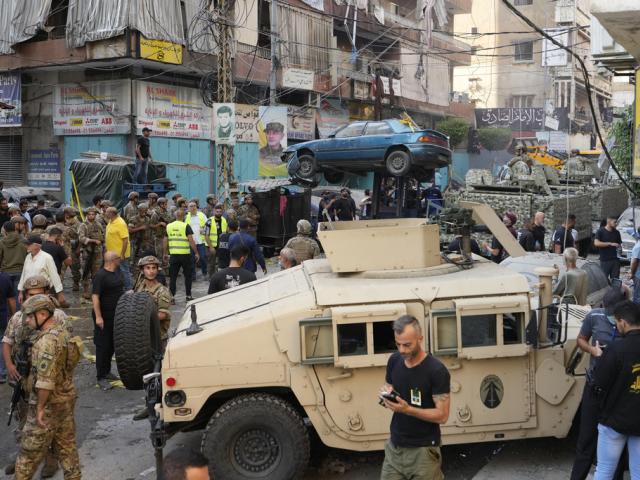 A forklift removes a damaged car as Lebanese army and emergency workers gather at the scene of an Israeli airstrike in Beirut&#039;s southern suburbs, Tuesday, Sept. 24, 2024. (AP Photo/Hassan Ammar)