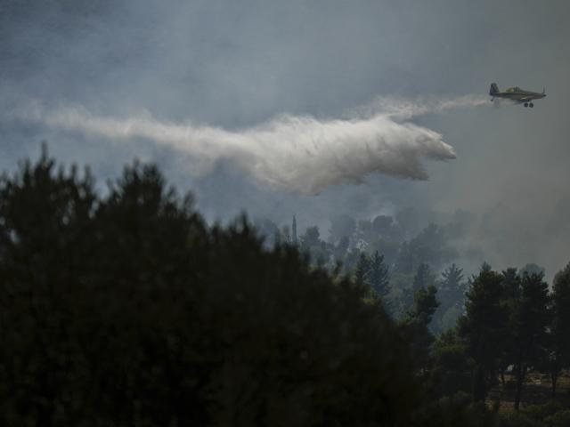 An Israeli firefighters plane uses a fire retardant to extinguish a fire after a rocket fired from Lebanon hit an open area near the city of Safed, northern Israel, on Wednesday, Sept. 25, 2024. (AP Photo/Leo Correa)