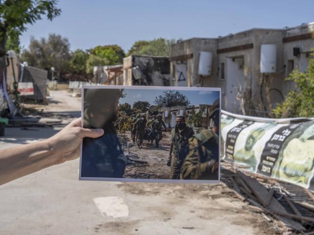 A photograph shows Israeli forces recovering the bodies of killed Israeli residents from a destroyed house in Kibbutz Kfar Aza, 2023, against the kibbutz backdrop almost a year later. Photo by: Ilia Yefimovich/picture-alliance/dpa/AP Images