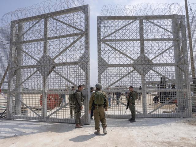 Israeli soldiers gather near a gate to walk through an inspection area for trucks carrying humanitarian aid supplies bound for the Gaza Strip, on the Israeli side of the Erez crossing into northern Gaza, on May 1, 2024. (AP Photo/Ohad Zwigenberg, File)