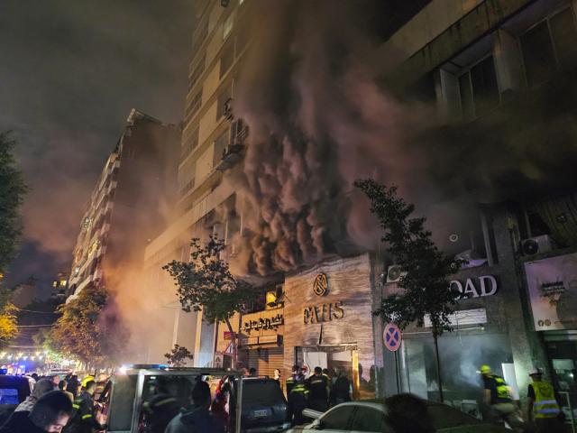 Civil defense workers extinguish a fire at the site of an Israeli airstrike in Beirut, Sunday, Nov. 17, 2024. (AP Photo/Hassan Ammar)