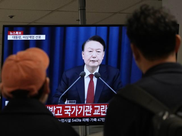 People watch a TV screen showing South Korean President Yoon Suk Yeol&#039;s televised briefing at a bus terminal in Seoul, South Korea, Tuesday, Dec. 3, 2024. (AP Photo/Ahn Young-joon)