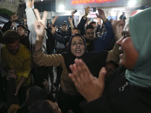 Palestinians celebrate the announcement of a ceasefire deal between Hamas and Israel in Deir al-Balah, central Gaza Strip, Wednesday, Jan. 15, 2025. (AP Photo/Abdel Kareem Hana)