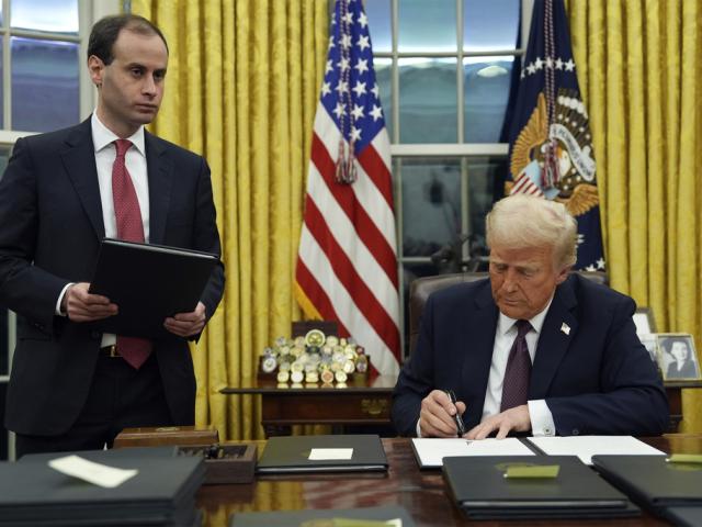 President Trump signs an executive order to create the Department of Government Efficiency (DOGE) in the Oval Office, Jan. 20, 2025, in Washington, as White House staff secretary Will Scharf watches. (AP Photo/Evan Vucci)