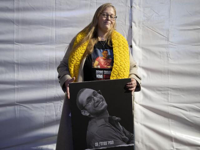 Herut Nimrodi poses with a poster of her son, Tamir Nimrodi, an Israeli soldier taken hostage on Oct. 7, 2023, and being held by Hamas militants in the Gaza Strip, at a rally in Tel Aviv, Israel, Jan. 14, 2025. (AP Photo/Maya Alleruzzo, File)