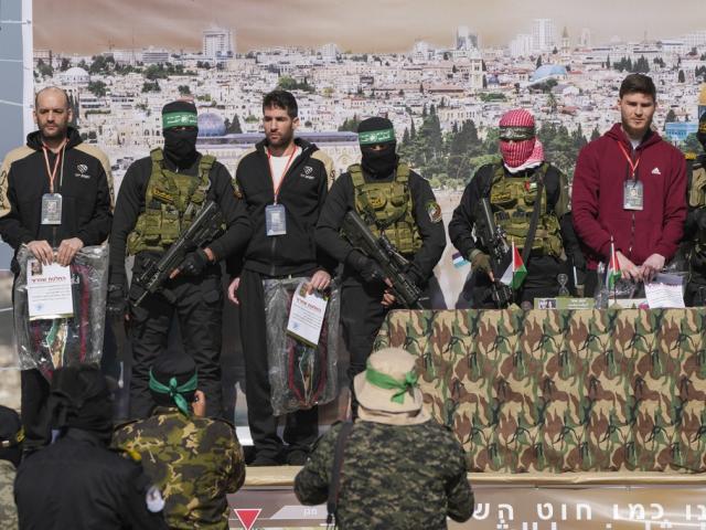 Israeli hostages Iair Horn, 46, Sagui Dekel Chen, 36, and Alexander Troufanov, 29, are escorted by Hamas and islamic Jihad fighters and are handed over to the Red Cross in the Gaza Strip, Feb. 15, 2025. (AP Photo/Abdel Kareem Hana)