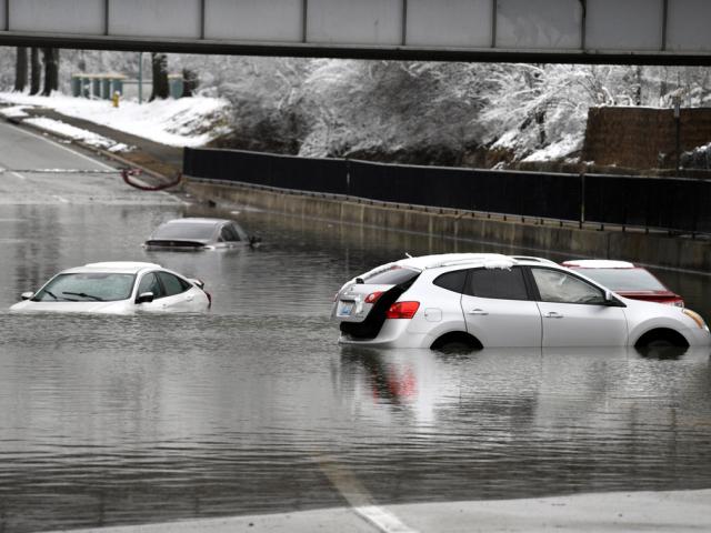 Cars sit in floodwaters at a railroad underpass in Louisville, Ky., Sunday, Feb. 16, 2025. (AP Photo/Timothy D. Easley)