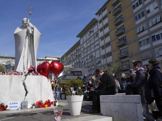 People pray outside the Agostino Gemelli Polyclinic in Rome, Sunday, Feb. 23, 2025, where Pope Francis is hospitalized since Feb. 14. (AP Photo/Gregorio Borgia)