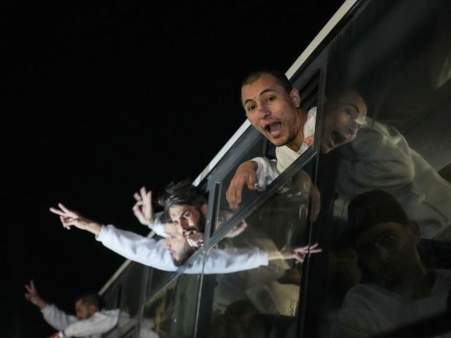 Freed Palestinian prisoners wave from a bus as they arrive in the Gaza Strip after being released from an Israeli prison following a ceasefire agreement between Hamas and Israel in Khan Younis, Gaza Strip, Feb. 27, 2025. (AP Photo/Abdel Kareem Hana)