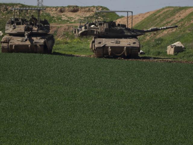 An Israeli soldier sits on the top of a tank near Israeli-Gaza border, as seen from southern Israel, Sunday, March 2, 2025. (AP Photo/Leo Correa)