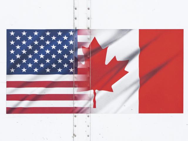 U.S. and Canada flags are seen on a transport truck trailer at the Pacific Highway Canada-U.S. border crossing in Surrey, British Columbia, on Tuesday, March 4, 2025. (Ethan Cairns/The Canadian Press via AP)