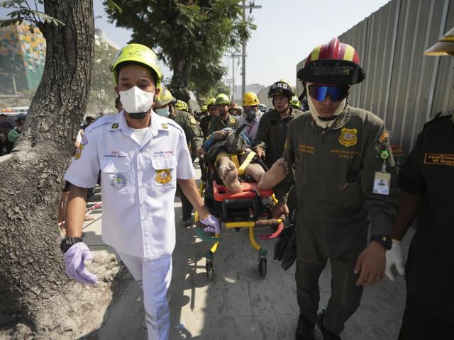 Rescuers carry an injured from the site of a high-rise building under construction that collapsed after a 7.7 magnitude earthquake in Bangkok, Thailand, Friday, March 28, 2025. (AP Photo/Sakchai Lalit)