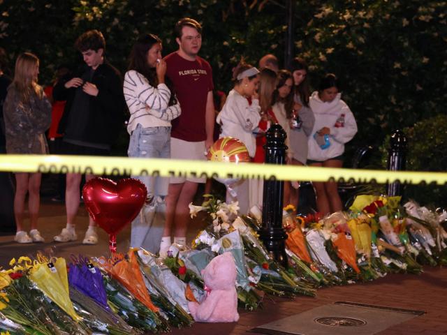 An impromptu memorial shared online brings students bearing flowers into the evening near the center of the Florida State campus in sight of the Student Union building, Tallahassee, Fla., Thursday, April 17, 2025. (AP Photo/Gary McCullough)