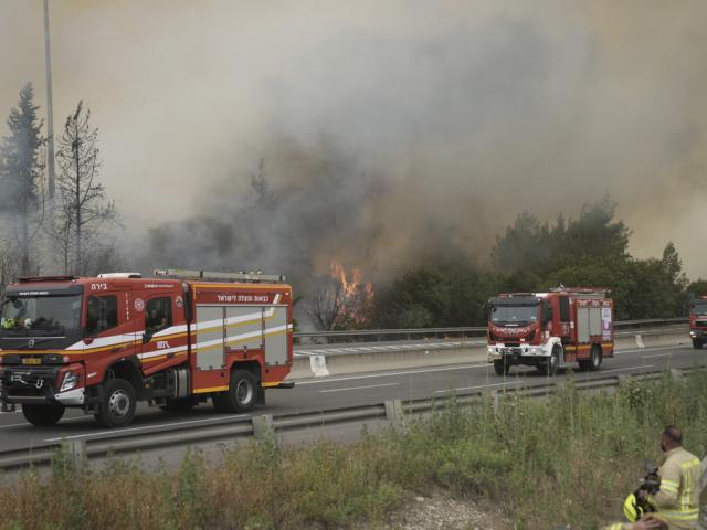 Firefighters work to extinguish a forest fire burning on a freeway to Jerusalem, Wednesday, April 30, 2025. (AP Photo/Mahmoud Illean)