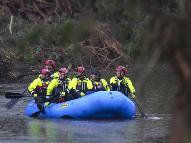 Officials ride a boat as they arrive to assist with a recovery effort at Camp Mystic along the Guadalupe River after a flash flood swept through the area Sunday, July 6, 2025, in Hunt, Texas. (AP Photo/Julio Cortez)