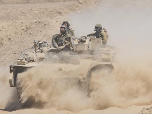 Israeli soldiers drive on their armored personnel carrier back from inside the northern Gaza Strip into southern Israel, Tuesday, July 29, 2025. (AP Photo/Ariel Schalit)